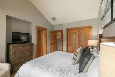 a bedroom with a bed and a flat screen tv at Fairway Drive 13113 by East West Hospitality in Truckee