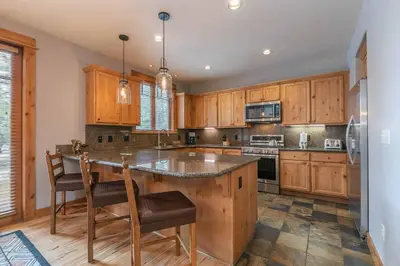 a kitchen with wooden cabinets and a large island at Fairway Drive 13113 by East West Hospitality in Truckee