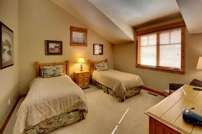 a bedroom with two beds and a desk at Gold Rush Trail 12560 by East West Hospitality in Truckee