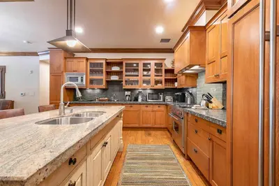 a large kitchen with wooden cabinets and a sink at Great Bear Lodge 206 by East West Hospitality in Truckee