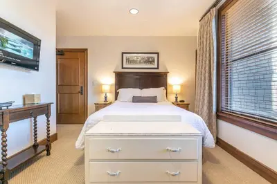 a bedroom with a white bed and a window at Great Bear Lodge 306 by East West Hospitality in Truckee