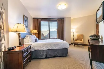 a bedroom with a bed and a desk and a window at Great Bear Lodge 306 by East West Hospitality in Truckee
