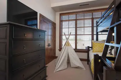 a bedroom with a dresser and a triangle toy at Great Bear Lodge 501 by East West Hospitality in Truckee