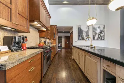 a large kitchen with wooden cabinets and a sink at Great Bear Lodge 501 by East West Hospitality in Truckee