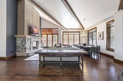 a large living room with a table and a fireplace at Great Bear Lodge 501 by East West Hospitality in Truckee