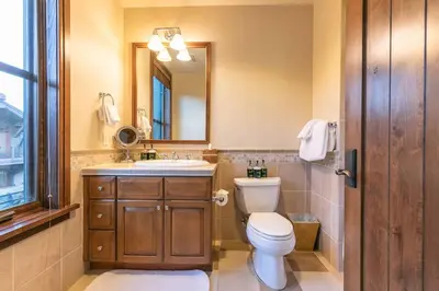a bathroom with a toilet and a sink and a mirror at Great Bear Lodge 302 by East West Hospitality in Truckee