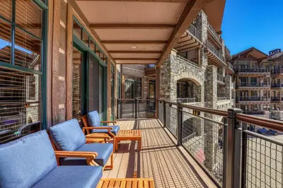 a balcony with two chairs and a railing at Great Bear Lodge 302 by East West Hospitality in Truckee