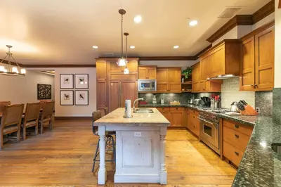 a large kitchen with wooden cabinets and a island in it at Great Bear Lodge 302 by East West Hospitality in Truckee