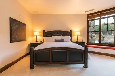 a bedroom with a bed and two lamps and a window at Great Bear Lodge 302 by East West Hospitality in Truckee