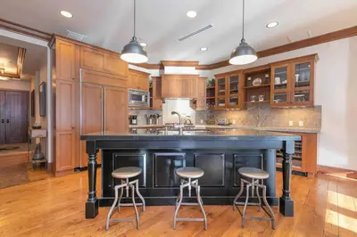 a kitchen with a large black island with bar stools at Great Bear Lodge 504 by East West Hospitality in Truckee