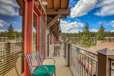 a balcony with a chair and a view at Iron Horse Lodge North 309 by East West Hospitality in Truckee