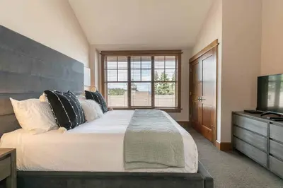 a bedroom with a large bed and a television at Iron Horse Lodge North 309 by East West Hospitality in Truckee