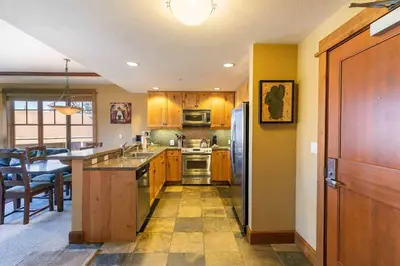 a kitchen with wooden cabinets and stainless steel appliances at Iron Horse Lodge North 209 by East West Hospitality in Truckee