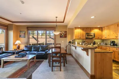 a kitchen and living room with a couch and a table at Iron Horse Lodge North 209 by East West Hospitality in Truckee