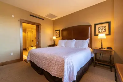 a hotel room with a large bed with white sheets at Iron Horse Lodge South 305 by East West Hospitality in Truckee