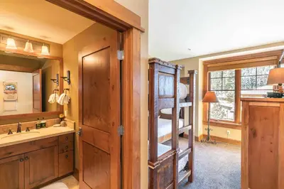 a bathroom with a bunk bed and a sink and a mirror at Iron Horse Lodge South 502 by East West Hospitality in Truckee