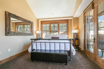 a bedroom with a bed and a mirror at Iron Horse Lodge South 502 by East West Hospitality in Truckee