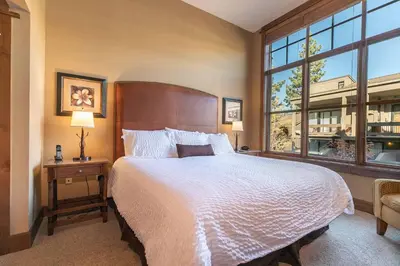 a bedroom with a large bed and a large window at Iron Horse Lodge North 107 by East West Hospitality in Truckee
