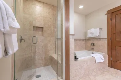 a bathroom with a shower with a tub and a sink at Iron Horse Lodge North 206 by East West Hospitality in Truckee