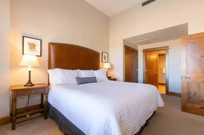 a bedroom with a large bed with a wooden headboard at Iron Horse Lodge North 305 by East West Hospitality in Truckee