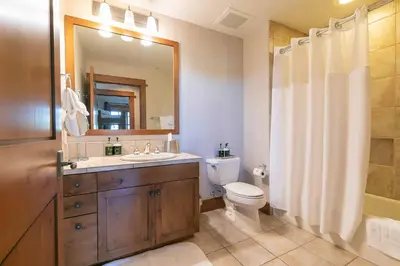 a bathroom with a sink and a toilet and a mirror at Iron Horse Lodge North 305 by East West Hospitality in Truckee