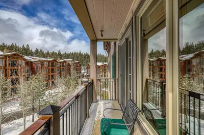 a balcony with a view of the snow covered trees at Iron Horse Lodge South 404 by East West Hospitality in Truckee