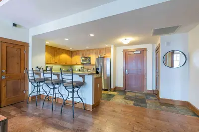 a kitchen with a counter and bar stools in it at Iron Horse Lodge South 404 by East West Hospitality in Truckee