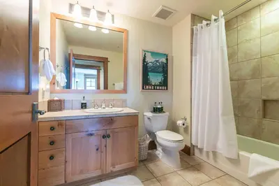 a bathroom with a sink and a toilet and a mirror at Iron Horse Lodge South 404 by East West Hospitality in Truckee
