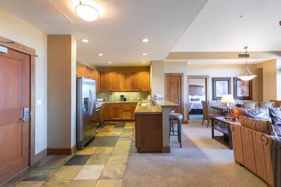 a kitchen and living room with a couch and a refrigerator at Iron Horse Lodge North 307 by East West Hospitality in Truckee