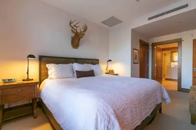 a bedroom with a bed with a deer head on the wall at Iron Horse Lodge South 209 by East West Hospitality in Truckee