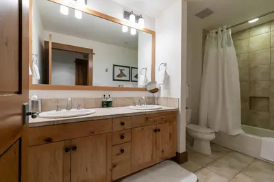 a bathroom with two sinks and a large mirror at Iron Horse Lodge South 209 by East West Hospitality in Truckee