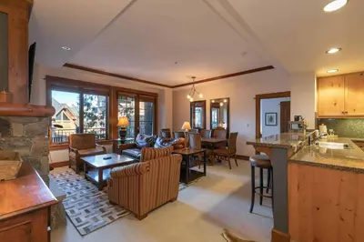 a kitchen and living room with a couch and a table at Iron Horse Lodge South 209 by East West Hospitality in Truckee