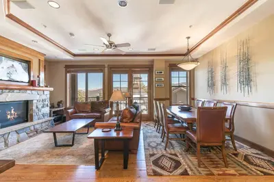 a living room with a table and chairs and a fireplace at Iron Horse Lodge South 401 by East West Hospitality in Truckee