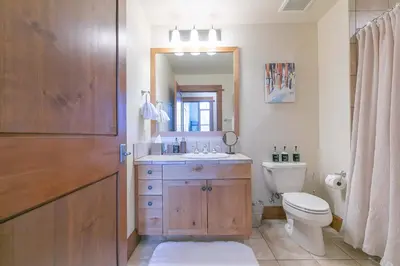 a bathroom with a toilet and a sink and a mirror at Iron Horse Lodge North 103 by East West Hospitality in Truckee