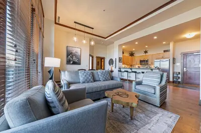 a living room with two couches and a kitchen at Iron Horse Lodge North 103 by East West Hospitality in Truckee