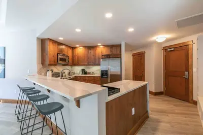 a kitchen with a large island with bar stools at Iron Horse Lodge South 308 by East West Hospitality in Truckee