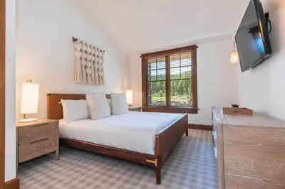 a bedroom with a bed and a flat screen tv at Iron Horse Lodge North 302 by East West Hospitality in Truckee