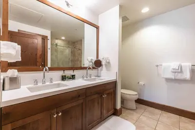 a bathroom with a sink and a toilet and a mirror at Iron Horse Lodge North 302 by East West Hospitality in Truckee