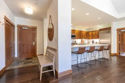 a kitchen with a bar with stools in it at Iron Horse Lodge North 302 by East West Hospitality in Truckee