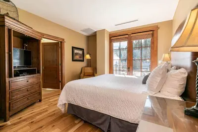 a bedroom with a bed and a flat screen tv at Iron Horse Lodge South 312 by East West Hospitality in Truckee