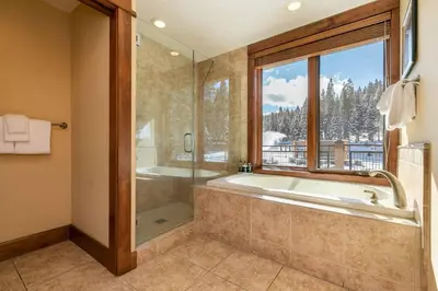 a bathroom with a tub and a window at Iron Horse Lodge South 312 by East West Hospitality in Truckee