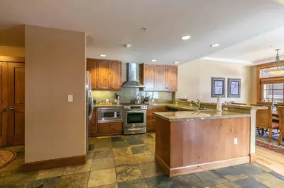 a kitchen with wooden cabinets and a stove top oven at Iron Horse Lodge South 312 by East West Hospitality in Truckee