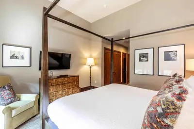 a bedroom with a four poster bed and a couch at One Village Place 508 by East West Hospitality in Truckee
