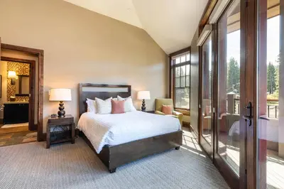 a bedroom with a bed and a large window at One Village Place 508 by East West Hospitality in Truckee