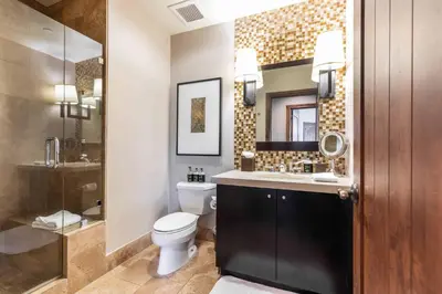 a bathroom with a toilet and a sink and a mirror at One Village Place 508 by East West Hospitality in Truckee