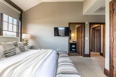 a bedroom with a bed and a tv on the wall at One Village Place 502 by East West Hospitality in Truckee