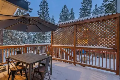 a wooden deck with a table and chairs and an umbrella at Bright 3BR Near Kings Beach and Northstar in Tahoe Vista