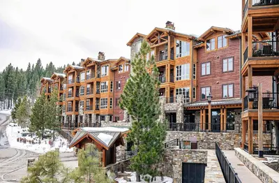 a large apartment building with a tree in front of it at Ski Trails 4099 by East West Hospitality in Truckee