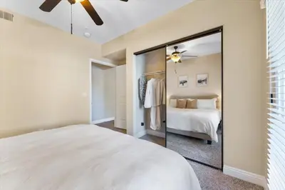 a bedroom with a white bed and a mirror at 2BR Getaway Pool Gym Basketball Court & Theater Access in Reno