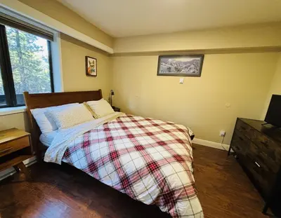 a bedroom with a bed with a plaid blanket at Knotty & Nice in Incline Village